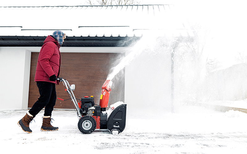 man using a snow blower